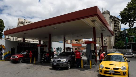 Expertos han alertado que la escasez los combustibles se agravará paulatinamente. En la foto, empleados bombean combustible en una estación de servicio en Caracas. (Foto: AFP)