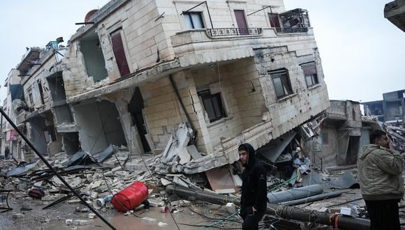 Los residentes se paran frente a un edificio derrumbado luego de un terremoto en la ciudad de Jandaris, en el campo de la ciudad de Afrin, en el noroeste de Siria. (Foto:  Rami al SAYED / AFP)
