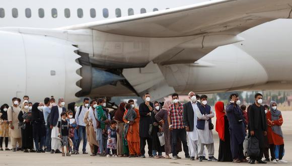 Algunos de los pasajeros tras desembarcar del avión procedente de Dubái con 290 evacuados de Afganistán, este martes en la base aérea de Torrejón de Ardoz. (Foto: EFE/Mariscal)
