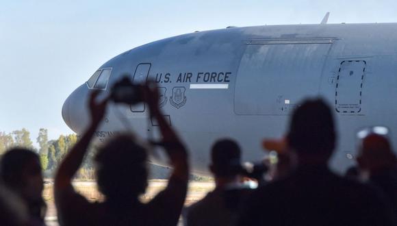 Representantes de los medios filman y toman fotografías de un avión de la fuerza aérea estadounidense estacionado en la pista después de un vuelo de evacuación de Kabul en la base naval de Rota, en el sur de España, el 31 de agosto de 2021. (CRISTINA QUICLER / AFP).