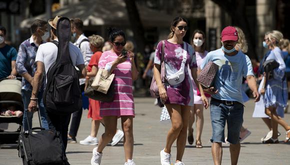 La gente camina sin usar máscaras faciales en Barcelona el 26 de junio de 2021.  (Foto de Josep LAGO / AFP)