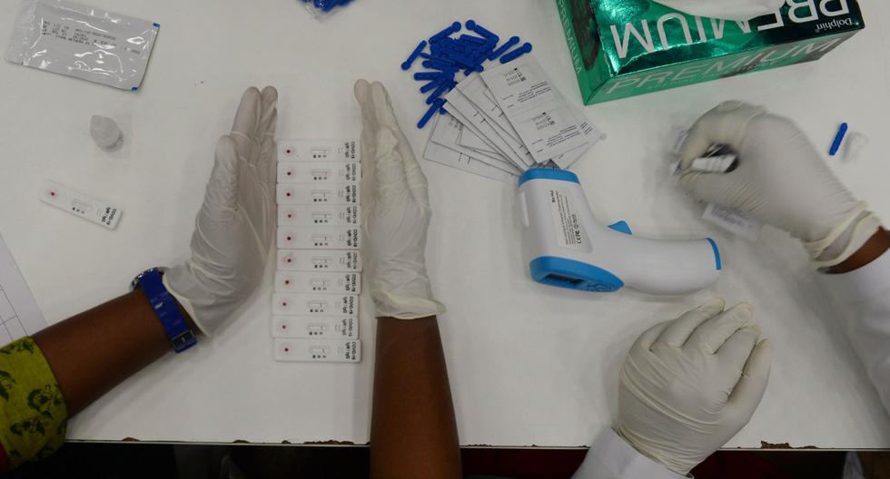 Imagen referencial. Técnicos médicos analizan muestras de COVID-19 en un centro de pruebas temporales en Chennai (India). (AFP / Arun SANKAR).