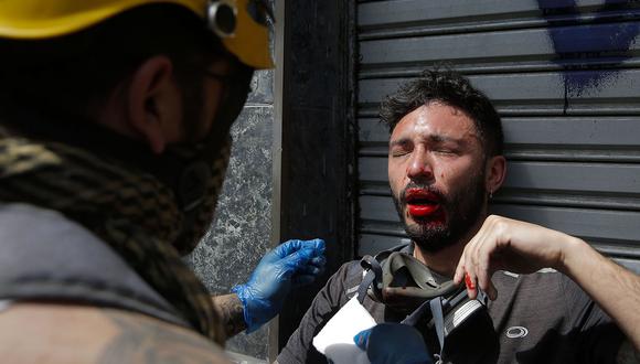 Un manifestante herido recibe asistencia durante las protestas en Chile. (Foto: AFP)