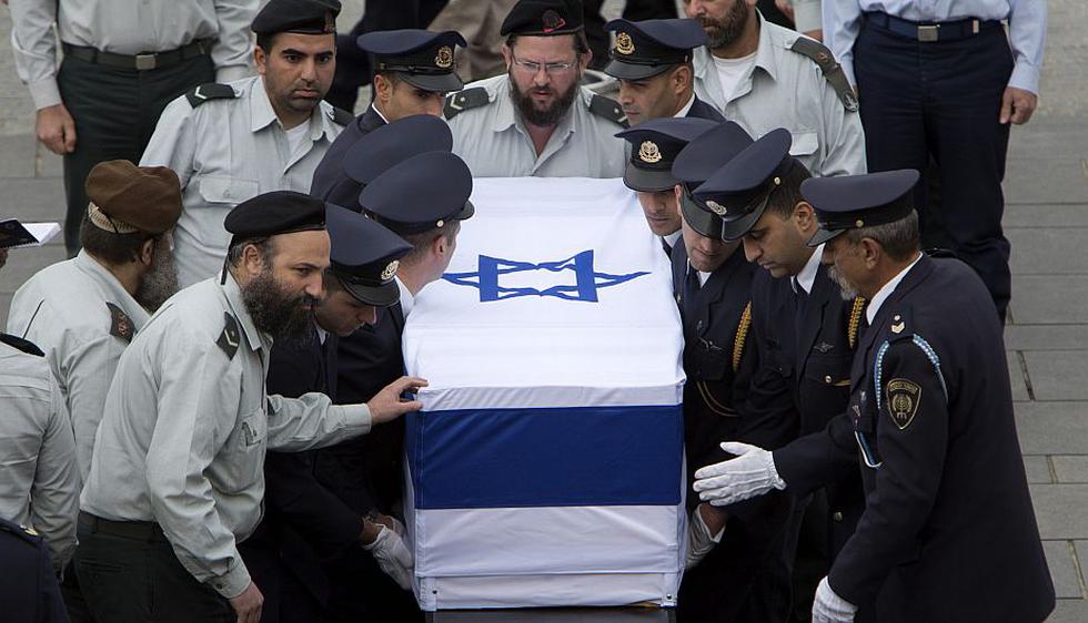 Miembros de la guardia Knesset cargando el cajón del exprimer ministro israelí Ariel Sharon en la plaza Knesset en Jerusalén. (AP)