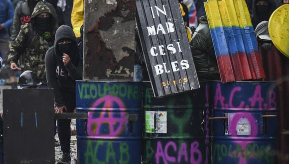 Los manifestantes sostienen escudos improvisados ​​mientras chocan con la policía antidisturbios durante una protesta contra el gobierno del presidente colombiano Iván Duque, en Bogotá el 9 de junio de 2021. (Juan BARRETO / AFP).