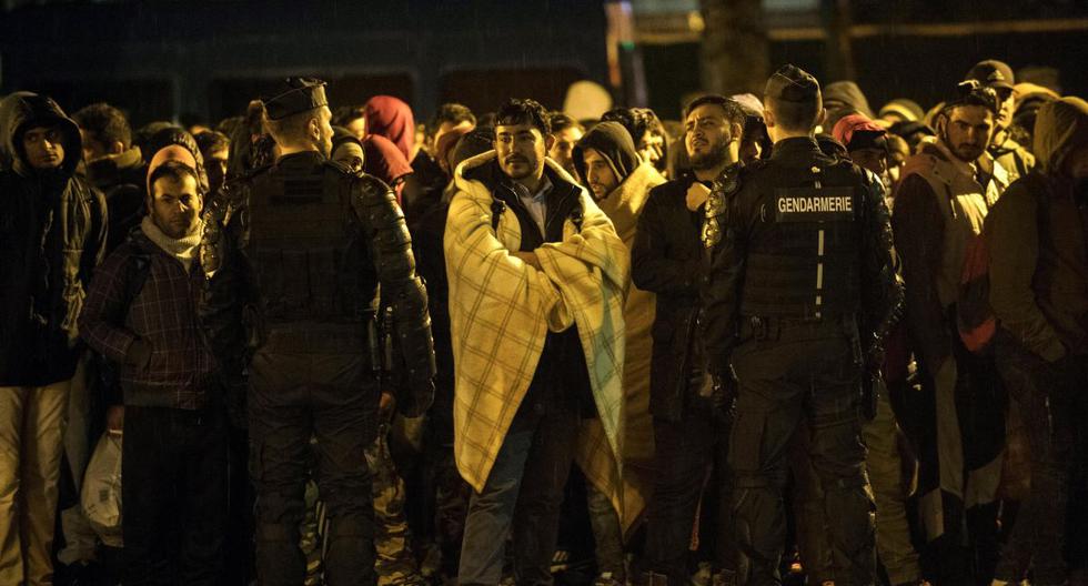 Los migrantes esperan para subir a un autobús durante una operación policial para despejar campamentos improvisados en el norte de París, Francia. (EFE)