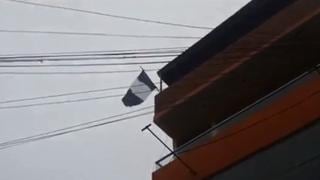 Bandera peruana blanca y negra flamea sobre una vivienda de Chancay