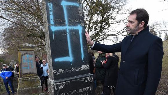 El ministro del Interior de Francia, Christophe Castaner, contempla una tumba vandalizada en el cementerio judío de Quatzenheim. (Foto: EFE)