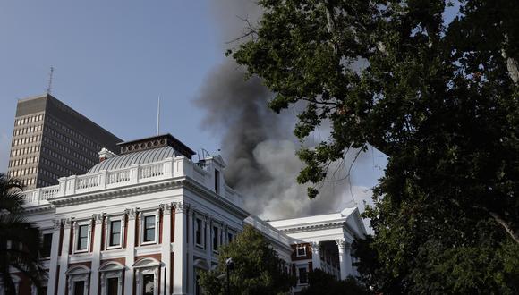 El humo sale del techo de un edificio en el recinto del Parlamento sudafricano en Ciudad del Cabo el 2 de enero de 2022, durante un incendio. (Foto: Marco Longari / AFP)