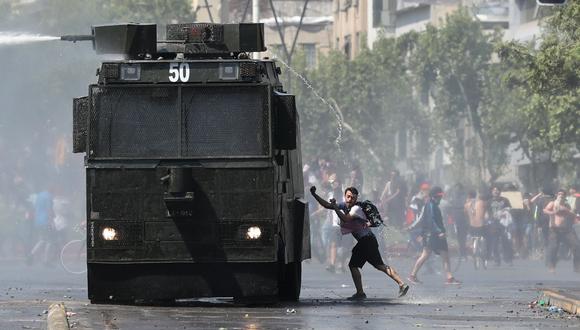 Una manifestante se acerca a un carro lanza agua de la policía durante una protesta en el centro de Santiago. (REUTERS/Ivan Alvarado).