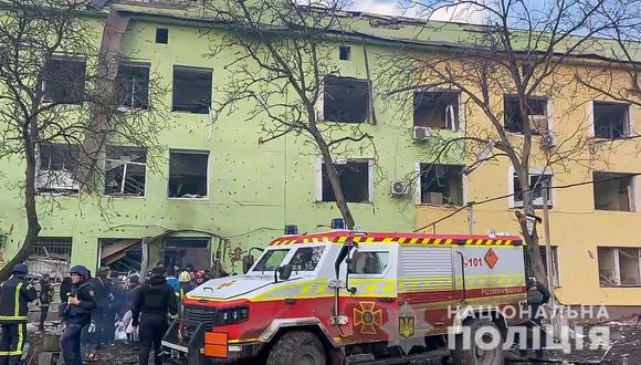 Esta captura de video del 9 de marzo de 2022 muestra a los servicios de emergencia frente a un edificio dañado de un hospital infantil luego de un ataque aéreo ruso en la ciudad de Mariupol. (Foto: National Police of Ukraine / AFP)