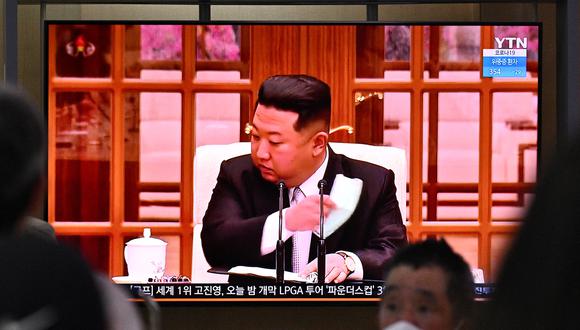 Las personas se sientan cerca de una pantalla que muestra una transmisión de noticias en una estación de tren en Seúl el 12 de mayo de 2022, del líder de Corea del Norte, Kim Jong Un. (Foto: Anthony WALLACE / AFP)