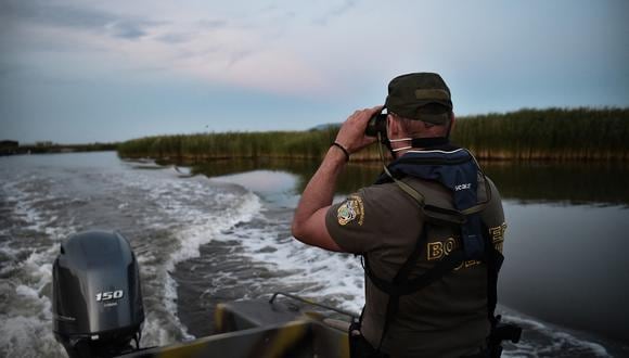 Un oficial de policía patrulla el delta del río Evros en un bote, cerca de Alexandroupoli, a lo largo de la frontera entre Grecia y Turquía, el 8 de junio de 2021.  (Foto por Sakis MITROLIDIS / AFP)