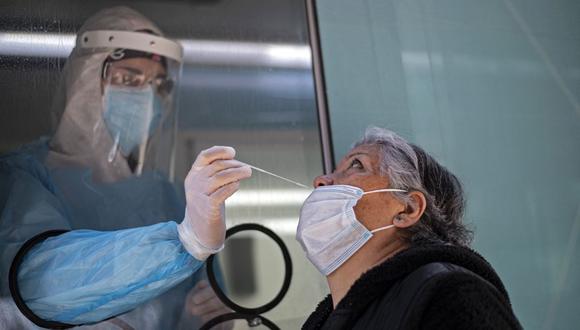 Una mujer se somete a una prueba de PCR para el nuevo coronavirus en el centro médico móvil del municipio de El Bosque, en Santiago, el 25 de agosto de 2020.  (Martin BERNETTI / AFP).