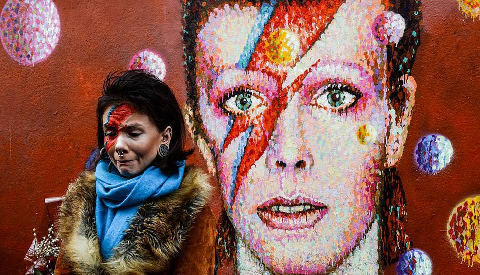 Una mujer llora ante el mural del artista Jimmy C en honor a David Bowie en el barrio londinense de Brixton. (AFP)
