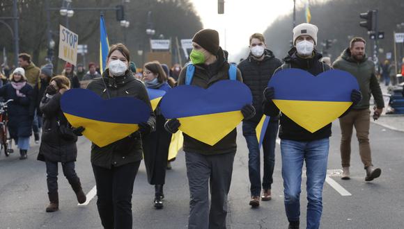 Los manifestantes con corazones en los colores de Ucrania marchan por la Strasse des 17. Juni road entre la columna de la Victoria y la Puerta de Brandenburgo en Berlín para manifestarse por la paz en Ucrania el 27 de febrero de 2022. (Foto: Odd ANDERSEN / AFP)