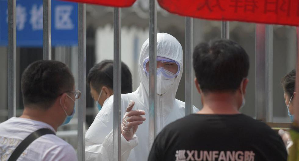 Imagen referencial. Una persona usa un traje protector en una estación de pruebas de coronavirus COVID-19 en Beijing el 28 de junio de 2020. (GREG BAKER / AFP).