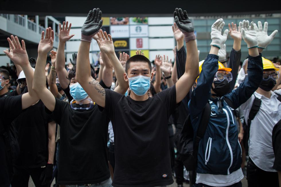 Miles de manifestantes vestidos de negro rodearon los edificios del Gobierno en Hong Kong y paralizaron la circulación, exigiendo que se retire el proyecto de ley, apoyado por Pekín. (Foto: EFE)