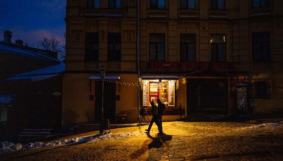 La gente camina por una calle en el centro de Kyiv el 6 de diciembre de 2022, en medio de la invasión rusa de Ucrania. (Foto de Dimitar DILKOFF / AFP)