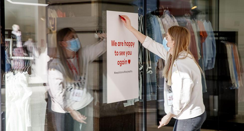Imagen referencial en la ciudad de Graz, Austria. Un empleado arregla un cartel que dice lo siguiente: "Estamos felices de verte de nuevo". (AFP / APA / ERWIN SCHERIAU).