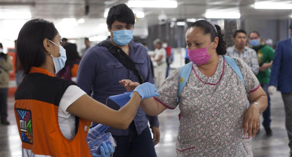 Un empleado entrega máscaras faciales en una estación de metro en la Ciudad de México, el 16 de abril de 2020. (CLAUDIO CRUZ / AFP).