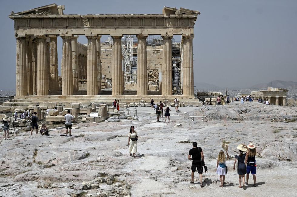 Los turistas visitan el sitio arqueológico de la antigua Acrópolis en Atenas (Grecia), el 1 de julio de 2021. (Louisa GOULIAMAKI / X07402 / AFP).