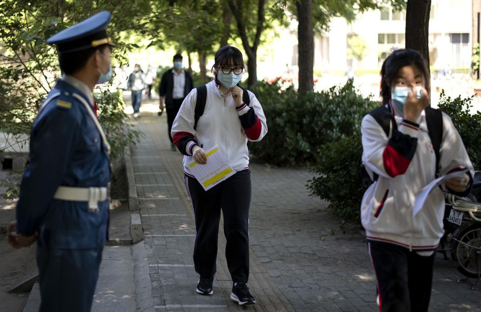 Estudiantes que usan máscaras faciales en medio de las preocupaciones por el coronavirus llegan a una escuela secundaria en Pekín el 11 de mayo de 2020. (Foto: AFP/Noel Celis)