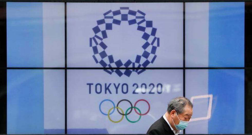 Un transeúnte con mascarilla pasa junto a una pantalla que muestra el logotipo de los Juegos Olímpicos de Tokio 2020 que han sido pospuestos a 2021 debido a la pandemia de la enfermedad del coronavirus (COVID-19), en Tokio, Japón, 14 de abril de 2021. REUTERS/Issei Kato