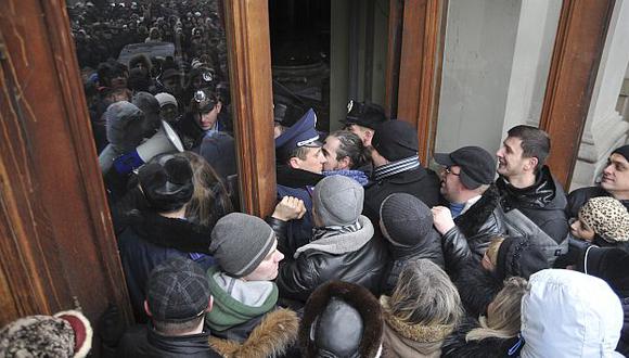 Cientos de manifestantes tratando de ingresar a la oficina del gobernador regional de Lviv. (AP)