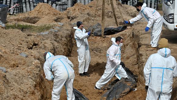 Trabajadores exhuman cuerpos de una fosa común en Bucha, al noroeste de Kiev, el 14 de abril de 2022. (Foto: Sergei SUPINSKY / AFP)
