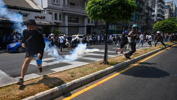 Los manifestantes corren después de que la policía lanzara gases lacrimógenos para dispersarlos durante una manifestación contra el golpe militar en Yangon. (Sai Aung Main / AFP)