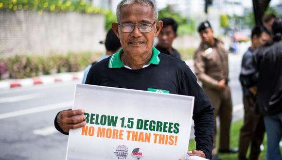 Un activista ambiental exhibe un cartel durante una manifestación frente al edificio de las Naciones Unidas en Bangkok, donde se desarrolla una conferencia climática de la ONU. (Foto: AFP)