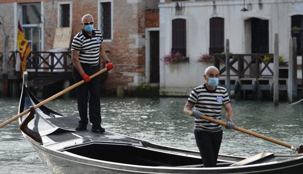 Las reconocidas góndolas de Venecia en Italia reaparecieron por el Gran Canal para transportar sobre todo a los habitantes locales debido a la larga ausencia de turistas por el coronavirus. (AFP / ANDREA PATTARO).