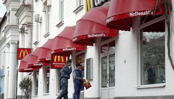 Dos hombres se paran en la entrada de un restaurante McDonald's cerrado en Sebastopol. (Foto: Vasiliy BATANOV / AFP)