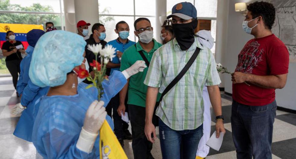 Trabajadores sanitarios despiden a un grupo de personas que se recuperaron del COVID-19 en un hotel sanitario en Caracas (Venezuela). (EFE/RAYNER PEÑA R.).