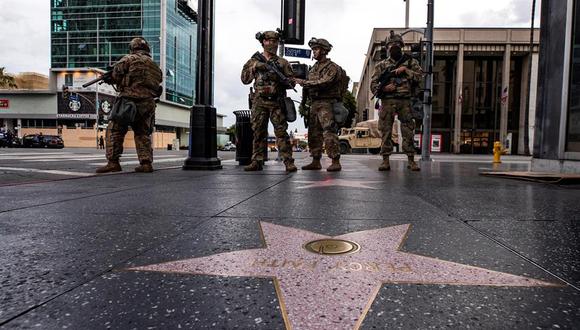 Soldados de la Guardia Nacional hacen guardia en el Paseo de la Fama durante el toque de queda mientras cientos de manifestantes salieron a la calle para manifestarse tras la muerte de George Floyd, en Hollywood, California. (EFE / EPA / ETIENNE LAURENT)