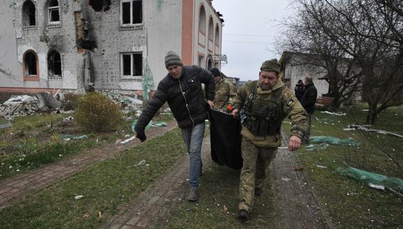Los rescatistas cargan un cuerpo en el pueblo de Andriivka, región de Kiev, el 10 de abril de 2022. (Foto de Sergei CHUZAVKOV / AFP)