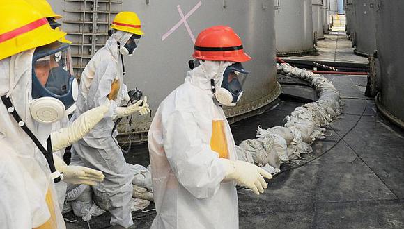 Trabajadores se protegen de radiación en la central nuclear de Fukushima. (AP)