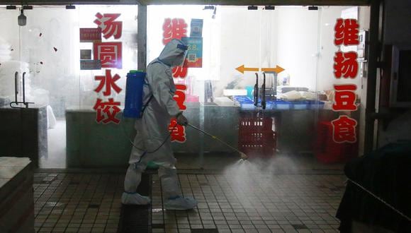 Esta foto tomada el 23 de agosto de 2021 muestra a un bombero rociando desinfectante en un mercado en Yangzhou, en la provincia de Jiangsu, en el este de China. (Foto: STR / AFP)