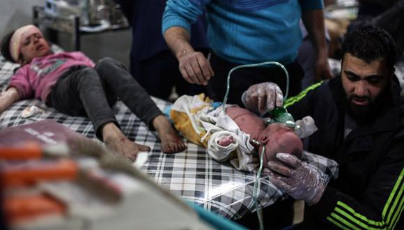 Un paramédico atiende a dos niños tras un bombardeo en Siria. (EFE)