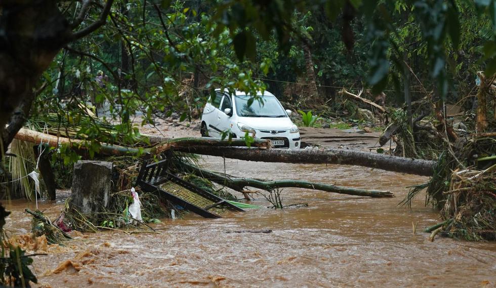 Se muestra un automóvil atascado en aguas de barro después de las inundaciones repentinas causadas por las fuertes lluvias en Thodupuzha, en el estado de Kerala, en India, el 16 de octubre de 2021 (Foto de Appu S. Narayanan / AFP).