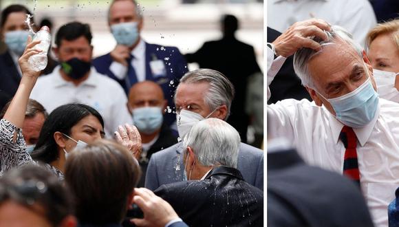 El mandatario de 72 años, Sebastián Piñera, intentó detener a la mujer, pero el agua ya había empapado su cabeza y su traje. (Foto: Dragomir Yankovic / ATON CHILE / AFP)