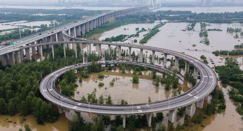 Esta vista aérea muestra un puente que conduce a la inundada isla de Tianxingzhou, que se convertirá en una zona de flujo de inundación para aliviar la presión del alto nivel de agua en el río Yangtze, en Wuhan. (Foto: STR / AFP)
