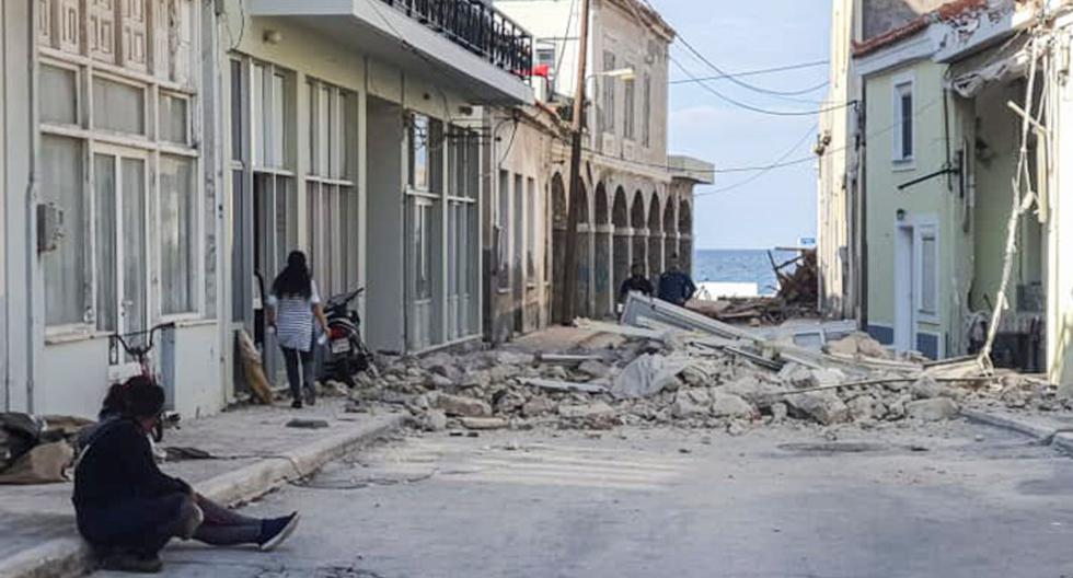 La gente pasa frente a una casa destruida después del terremoto en la isla de Samos el 30 de octubre de 2020. (AFP / Eurokinissi / STR).