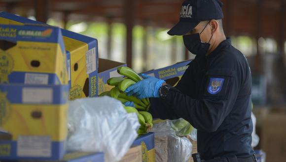 Un miembro de la Unidad de Información Portuaria de la Policía Antinarcóticos revisa cajas de banano con destino a Italia en el puerto de Guayaquil, Ecuador, el 12 de abril de 2022. (Foto de Marcos Pin / AFP)