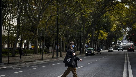 Una mujer con una mascarilla cruza la avenida Liberdade en Lisboa. Los portugueses apoyan el uso de la mascarilla obligatoria en exteriores. (AFP)