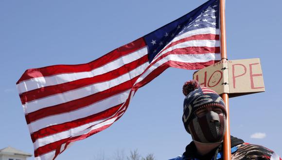 Imagen referencial de 12 de mayo. 
Un hombre sostiene una bandera estadounidense. (AFP/JEFF KOWALSKY).