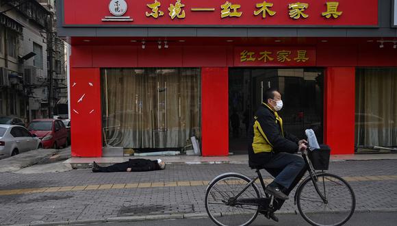 Hombre muerto tendido en el suelo en China (Foto: AFP/Héctor Retamal)