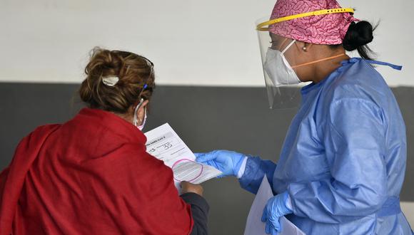 Una mujer recibe los resultados de su prueba de COVID-19 en el estacionamiento del centro comercial Via Vallejo en la Ciudad de México. (Foto: ALFREDO ESTRELLA / AFP)
