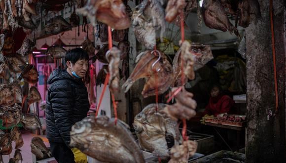 Un vendedor que vende pescado seco trabaja en su puesto en un mercado en Wuhan, provincia de Hubei, en el centro de China, el 15 de enero de 2021. (Foto de NICOLAS ASFOURI / AFP)
